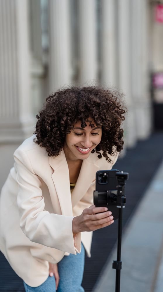 Creadora acomodando el celular en el trípode para grabar